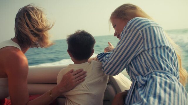 Happy family enjoys a serene boat trip across the beautiful ocean. Two women and a child share a joyful summer vacation experience, creating lasting memories.
