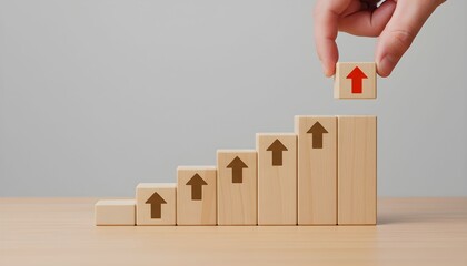 A hand placing a wooden block with an upward arrow on a staircase made of blocks.