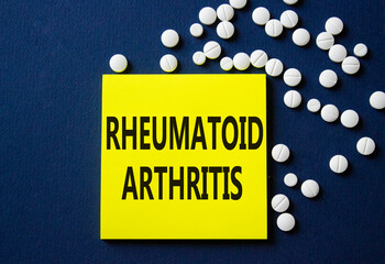 Rheumatoid Arthritis symbol. Concept word Rheumatoid Arthritis on yellow note. Beautiful deep blue background with pills. Medicine and Rheumatoid Arthritis concept. Copy space