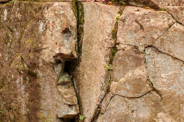 A large boulder within  Bond Falls Scenic Site, near Paulding, Michigan, with its cracks and protrusions, has created a face along the rocky wall