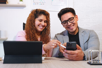 Smiling business professionals collaborating in a modern office, using technology to enhance teamwork and productivity