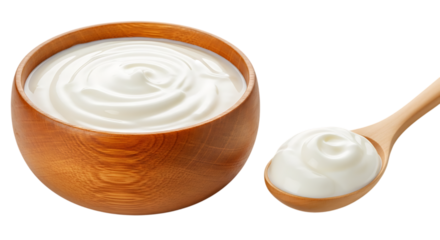 A close up high angle studio shot of creamy white yogurt swirling in a rustic wooden bowl next to a wooden spoon filled with a dollop of the same smooth yogurt against a stark black background