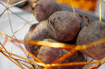 Fresh raw beetroots placed in a modern metallic basket.