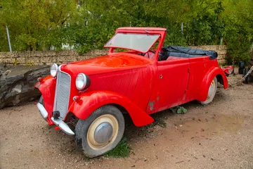 Fotobehang Fiets Vintage convertible passenger car in red on a clear sunny day. Transportation recreation sports hobbies travel  © Victor1153