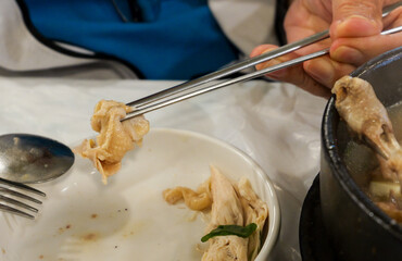 Eating Samgyetang Chicken Soup with Chopsticks