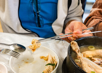 Eating Samgyetang Chicken Soup with Chopsticks