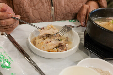 Eating Samgyetang Chicken Soup with Spoon and Fork