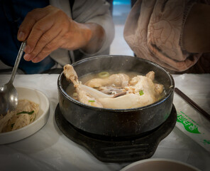 Steaming Samgyetang Ginseng Chicken Soup in Black Bowl