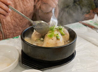 Steaming Samgyetang Ginseng Chicken Soup in Black Bowl