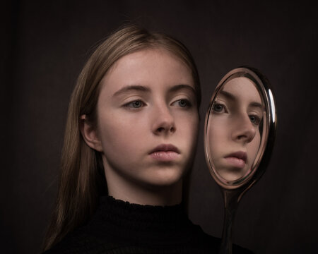 painterly dark renaissance art portrait of young blonde girl  in black dress holding silver hand mirror with her reflection
