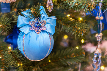 Elegant Christmas decoration in form of blue vintage ball with shiny decorations on festive Christmas tree