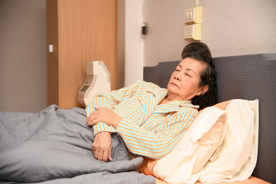 An old woman is sleeping on the bed - Powered by Adobe