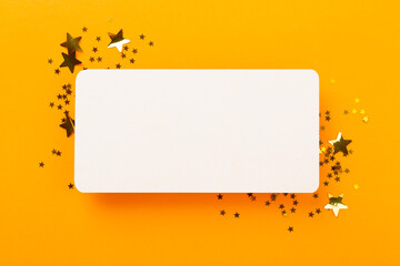 Golden star shape confetti on color background, top view