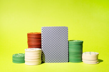 Poker chips and playing cards on color background. Casino card game