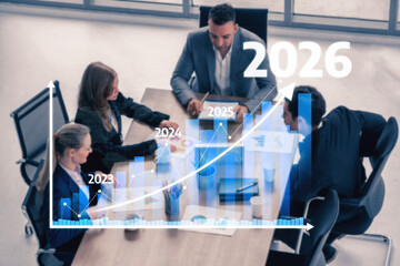Business professionals engage in a strategic meeting, analyzing data graphs to forecast future growth and discussing key performance indicators for success. Tessel
