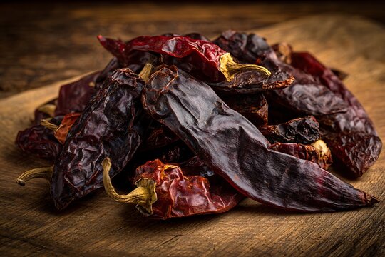 Dried chili peppers on wooden surface for spicy cooking