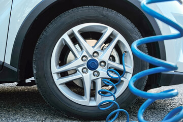 Inflating Car Tire with a Blue Air Compressor Hose