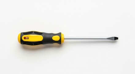 A flathead screwdriver with a yellow and black handle rests on a white surface.