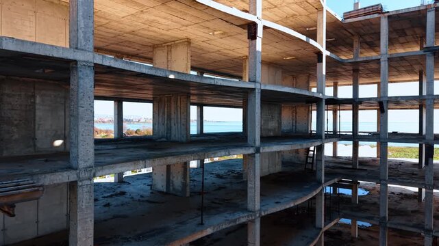 Footage in the multi-storied building with a large open central space in the middle. Flight along the floor revealing view on the blue seascape.