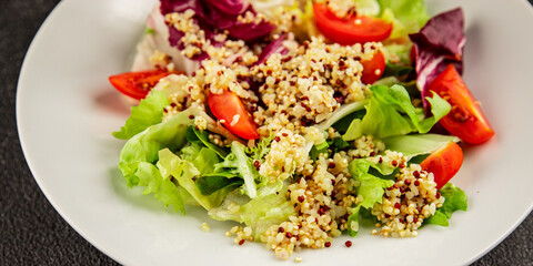 Quinoa salad tomato, green leaf salad vegetables dish natural product tasty snack fresh gourmet food background on the table rustic top view copy space keto and paleo diet vegan and vegan food