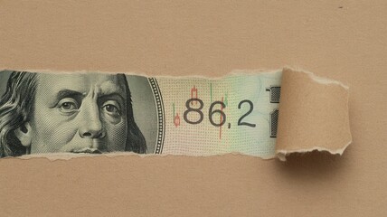 Fragment of denomination showing portrait and numerical data is revealed through torn brown paper