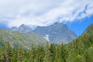 Scenic Svaneti landscape featuring rugged mountains covered with dense forests under natural light.