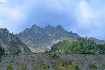 Scenic Svaneti landscape featuring rugged mountains covered with dense forests under natural light.