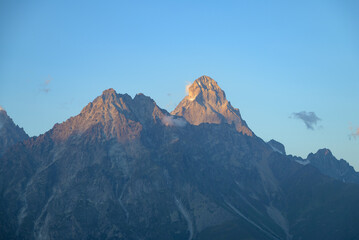 Scenic view of Mount Ushba in Svaneti, Georgia, with rugged peaks, forests, and valleys under natural light.