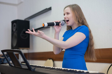 Caucasian woman singing into microphone. 
