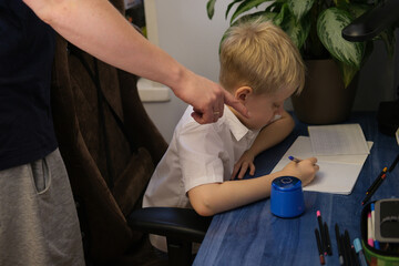 Parent pointing at unhappy child doing homework studying education