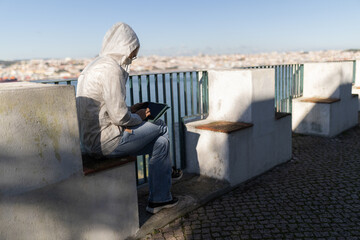 Person working on tablet overlooking urban cityscape
