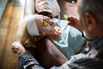 Smiling senior couple enjoying spa facial at home