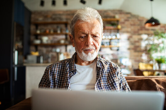 Senior man concentrating on laptop at home