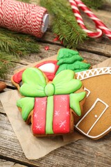Tasty gingerbread cookies, twine and Christmas decor on wooden table, closeup