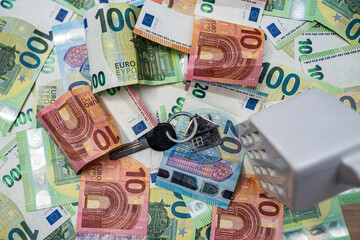 House model and keys on euro banknotes, real estate investment, mortgage and property finance concept