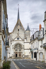 Fototapeta premium Historic stone tower of Eglise Saint Symphorien church rises above the Paul Bert district houses in Tours France creating a beautiful city landscape view across the river under the cloudy sky