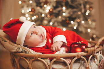 Little girl lays on a holiday background in Santa costume