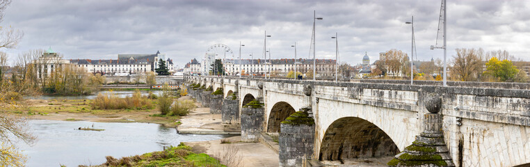 Historic stone arched Wilson Bridge crosses the Loire River towards the city center of Tours France...