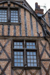 Close up view of historic half-timbered house facade with red brick herringbone pattern masonry and...