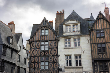 Tall historic half-timbered houses with wooden beams and red brick facades stand on Place Plumereau in Tours France creating a beautiful medieval city architecture landscape view outdoors