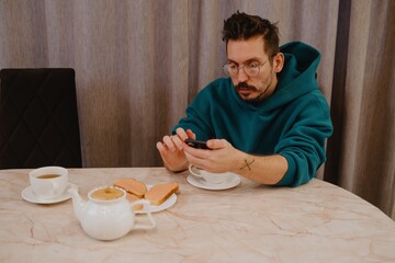 A young man and his female friend chat over tea in a cozy kitchen. Authentic moment of casual conversation and friendly connection in everyday setting
