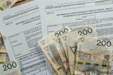 200 Polish zloty bills with PIT-11 tax declaration form, financial report, payment and accounting concept