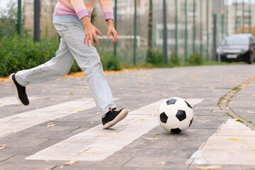 Little girl catching ball on pedestrian crossing outdoors, closeup. Child in danger and road safety