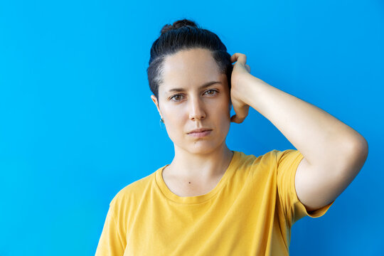 Authentic young woman with minimalist style and serious expression