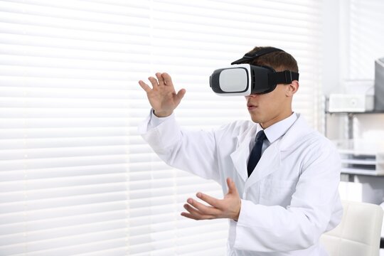 Modern technology. Doctor using virtual reality headset indoors, space for text