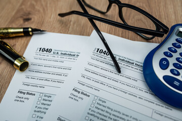 Form 1040 tax documents with calculator and fountain pen for 2025 financial filing