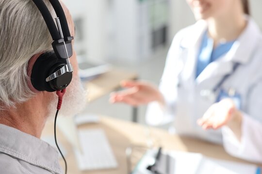 Patient with audiometric headphones undergoing hearing test in clinic, selective focus. Space for text - Powered by Adobe