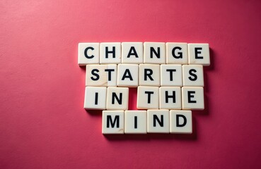 Scrabble tiles spell out Change Starts In The Mind on a red surface. Positive concept of mental shift and personal growth. New beginnings and fresh perspectives.