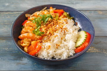 Khao Pad aux crevettes dans un bol bleu, cuisine thaïlandaise, fond bleu rustique