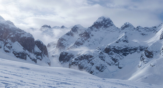 Mountain winter landscape with snow-covered peaks and cold sky